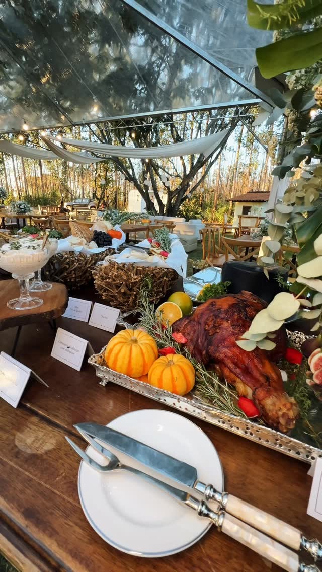 Mesa de buffet cercada por flores e folhagens